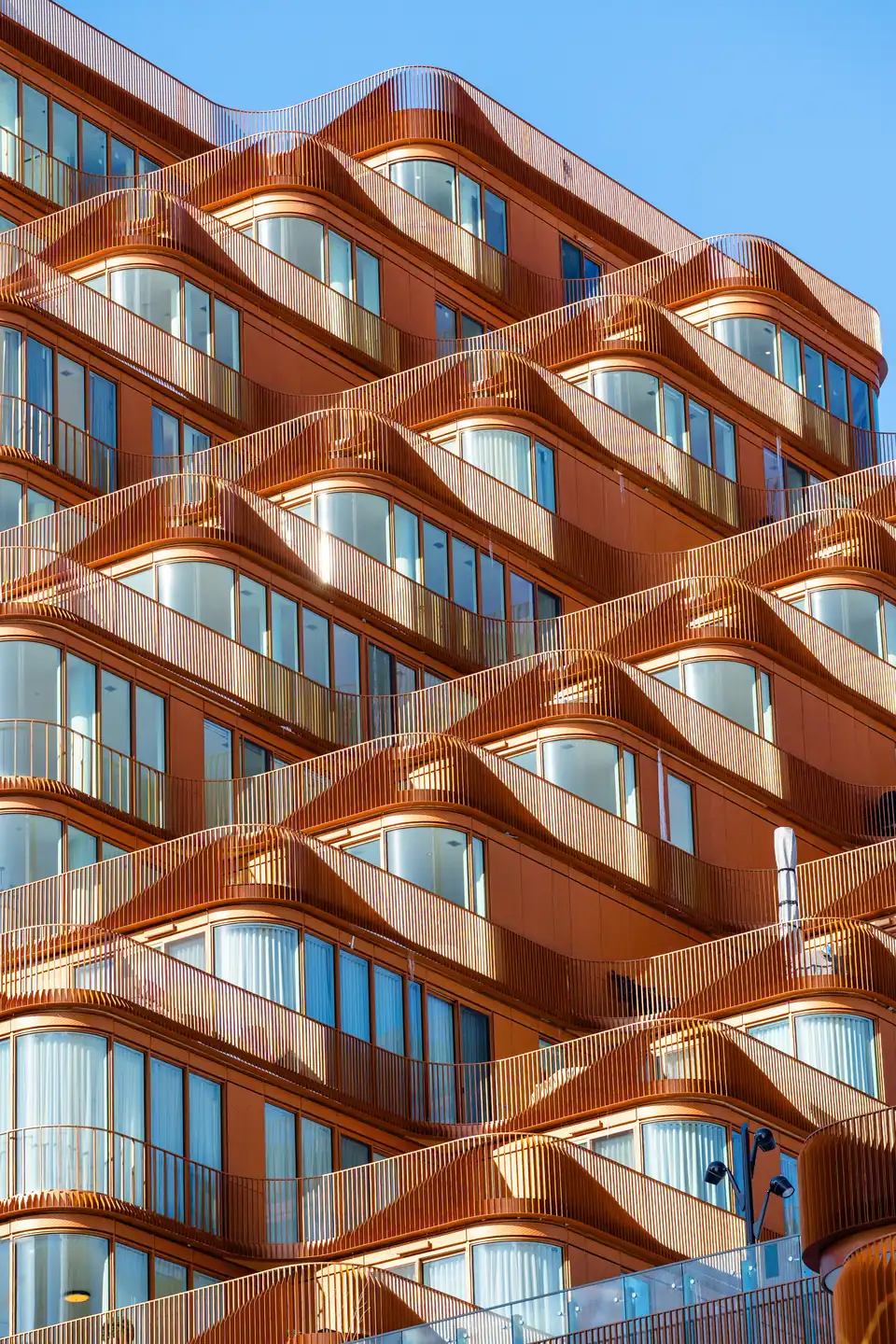 Curved balconies rippling across the face of a modern apartment building