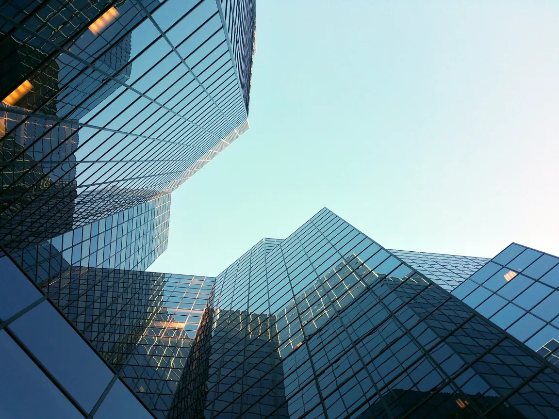 Glass office towers seen from street level against a clear sky
